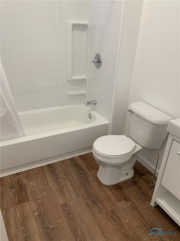 full bathroom with shower / tub combo with curtain, wood-type flooring, toilet, and vanity