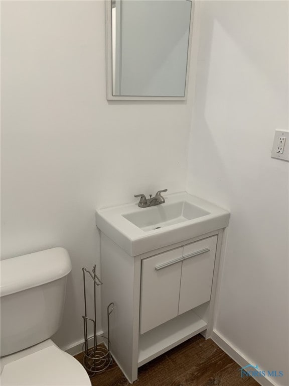 bathroom with hardwood / wood-style flooring, vanity, and toilet