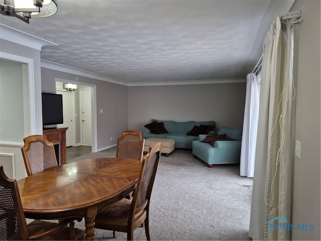 dining space featuring ornamental molding, carpet flooring, and a textured ceiling