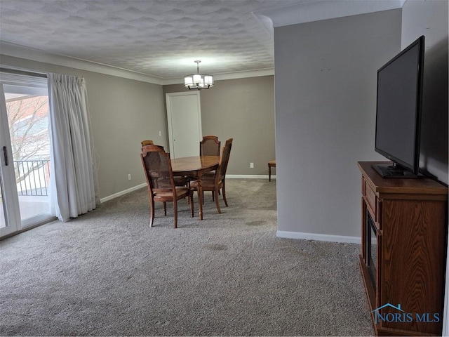 dining space featuring crown molding, carpet flooring, a textured ceiling, and a chandelier