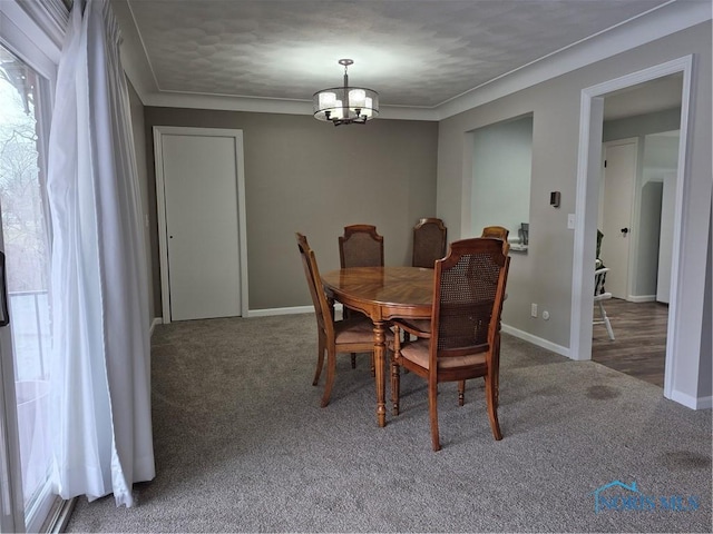 carpeted dining space featuring ornamental molding and a chandelier