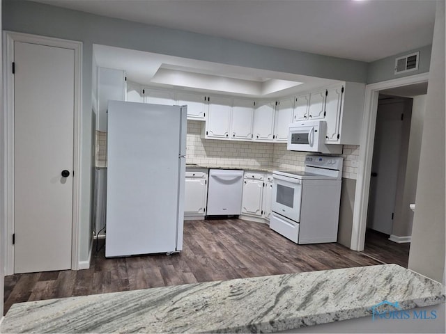 kitchen with a tray ceiling, backsplash, white appliances, and white cabinets