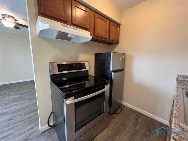 kitchen with appliances with stainless steel finishes, dark hardwood / wood-style floors, a textured ceiling, and ceiling fan