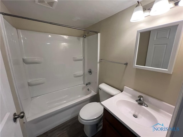 full bathroom featuring hardwood / wood-style flooring, vanity, washtub / shower combination, and toilet