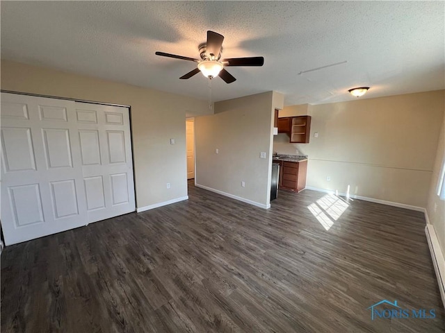 unfurnished living room with ceiling fan, dark hardwood / wood-style floors, a textured ceiling, and baseboard heating