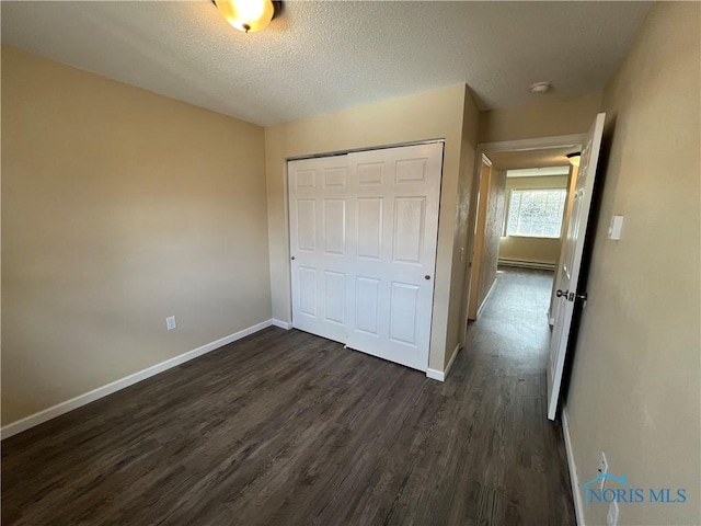 unfurnished bedroom featuring dark hardwood / wood-style floors, a closet, and a textured ceiling