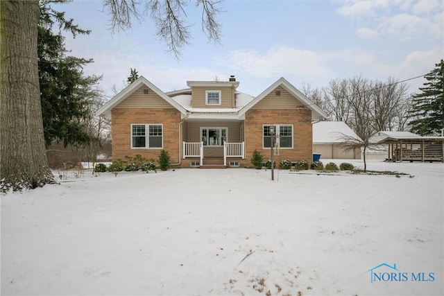 snow covered rear of property featuring a porch and a chimney