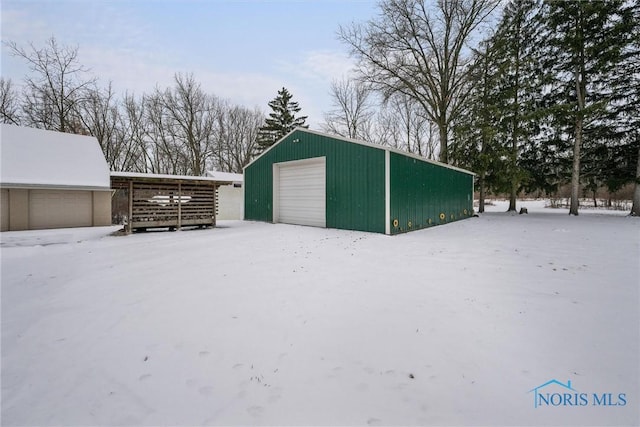 snow covered structure featuring a garage