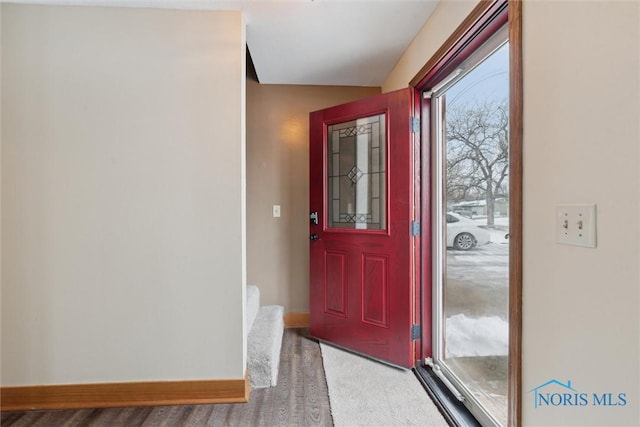 foyer entrance featuring carpet flooring and baseboards
