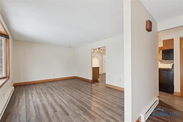 spare room with light hardwood / wood-style floors and a baseboard heating unit