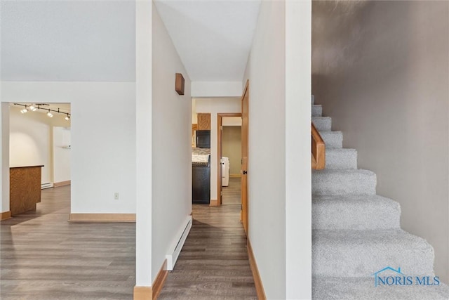 stairway featuring a baseboard radiator and hardwood / wood-style floors