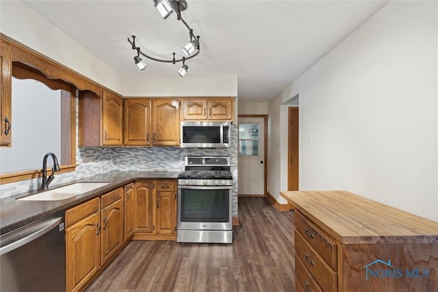 kitchen featuring appliances with stainless steel finishes, wooden counters, decorative backsplash, sink, and dark hardwood / wood-style floors