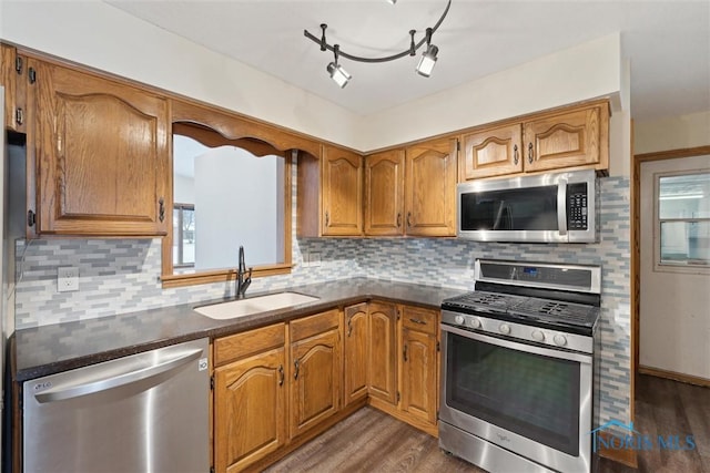 kitchen with dark hardwood / wood-style flooring, decorative backsplash, sink, and stainless steel appliances