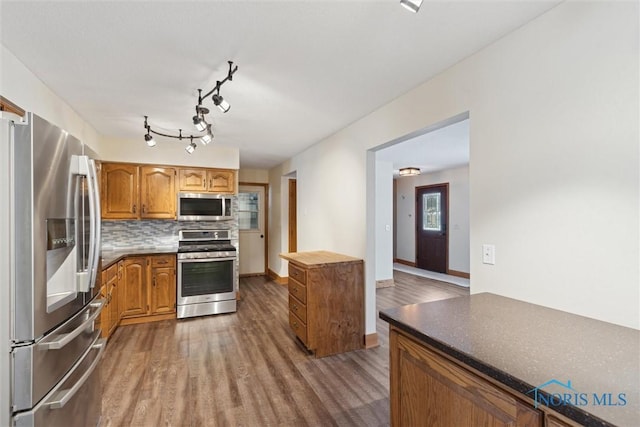 kitchen with stainless steel appliances, dark hardwood / wood-style floors, and backsplash