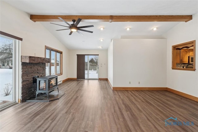 unfurnished living room featuring a wood stove, wood-type flooring, lofted ceiling with beams, and ceiling fan