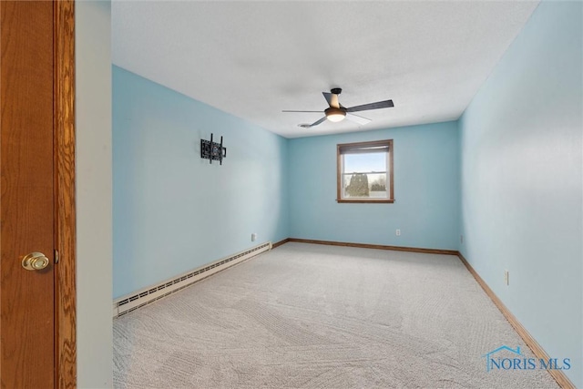 carpeted spare room featuring a baseboard heating unit and ceiling fan