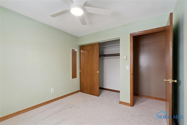 unfurnished bedroom with a closet, light colored carpet, and ceiling fan