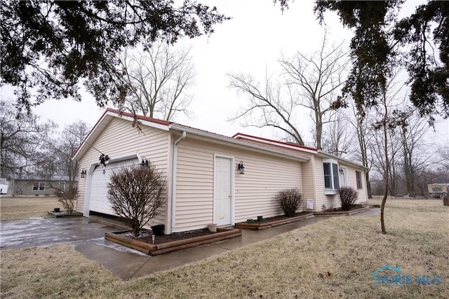 view of property exterior featuring a garage and a lawn