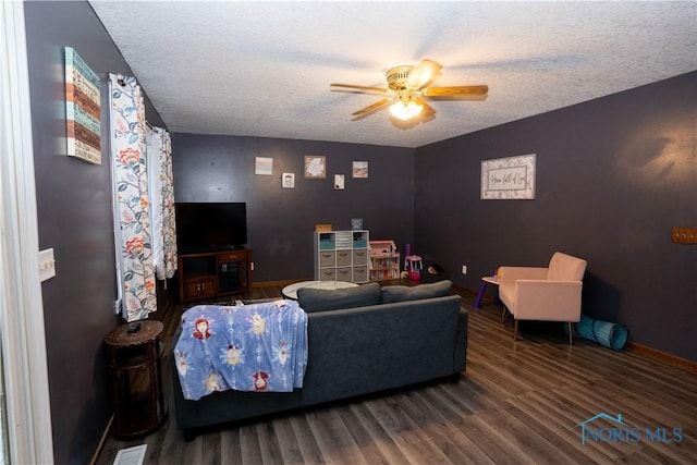 living room featuring wood-type flooring, a textured ceiling, and ceiling fan