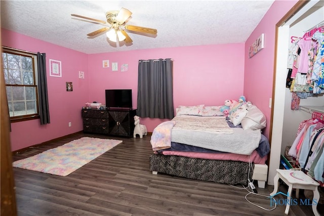 bedroom with ceiling fan, dark hardwood / wood-style floors, and a textured ceiling