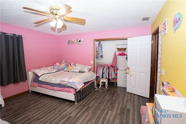 bedroom with dark wood-type flooring, a closet, ceiling fan, and a textured ceiling