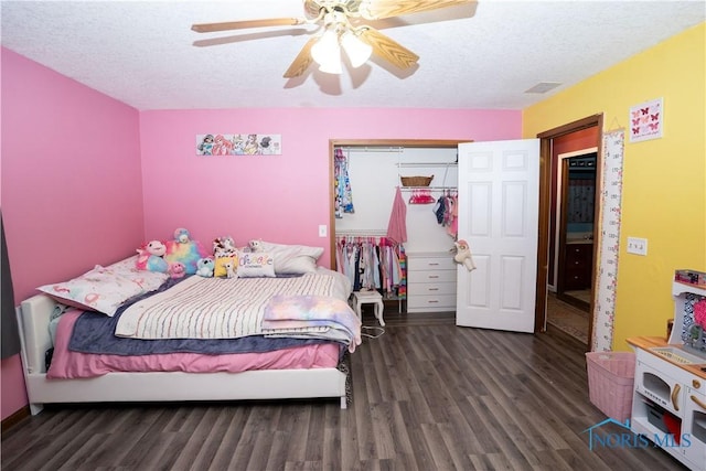 bedroom featuring ceiling fan, dark hardwood / wood-style flooring, a closet, and a textured ceiling