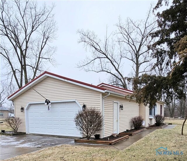 view of property exterior featuring a garage and a yard