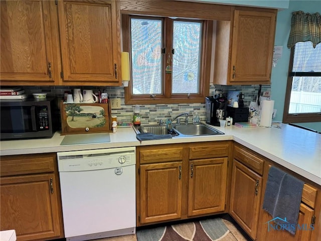 kitchen featuring dishwasher, sink, and backsplash