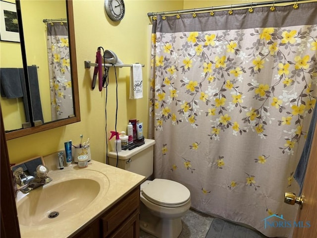 bathroom with vanity, curtained shower, and toilet