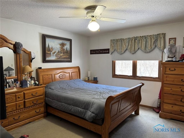 bedroom with ceiling fan, carpet flooring, and a textured ceiling