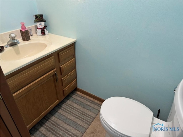 bathroom featuring vanity, tile patterned floors, and toilet