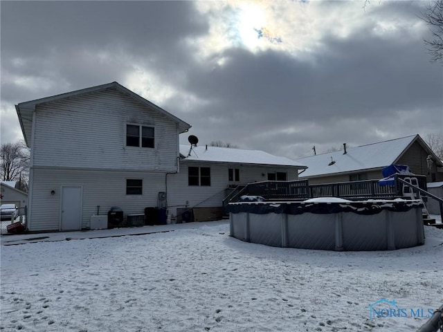 snow covered house with central AC and a covered pool