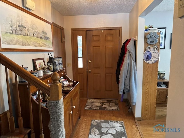 entrance foyer featuring a textured ceiling and light hardwood / wood-style floors