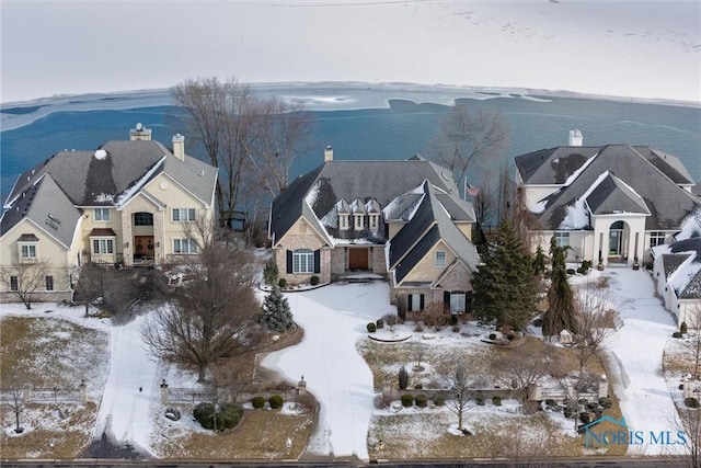 snowy aerial view with a water view