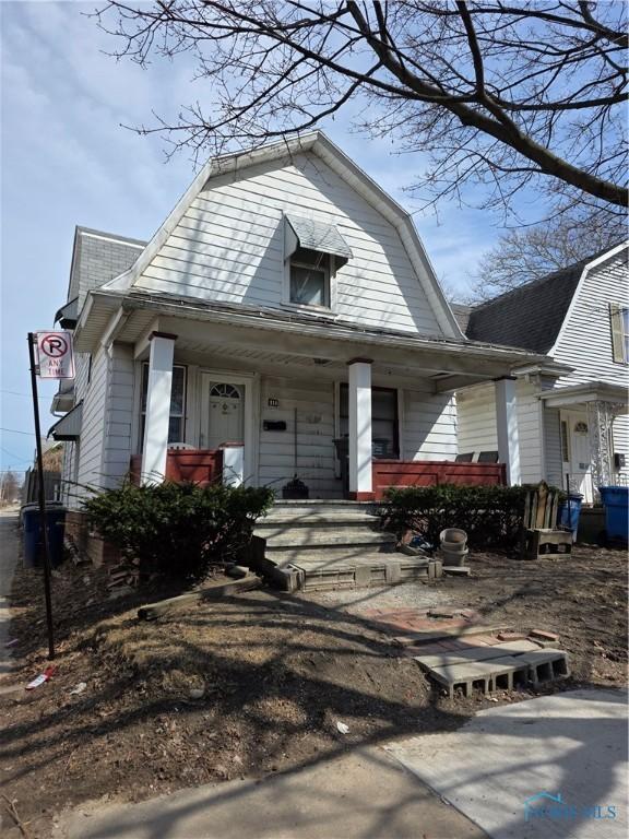 dutch colonial with a porch, a gambrel roof, and a shingled roof