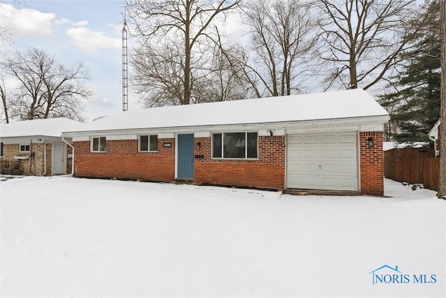 single story home featuring brick siding, fence, and an attached garage