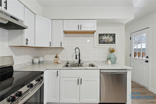 kitchen with white cabinetry, appliances with stainless steel finishes, light stone countertops, and sink