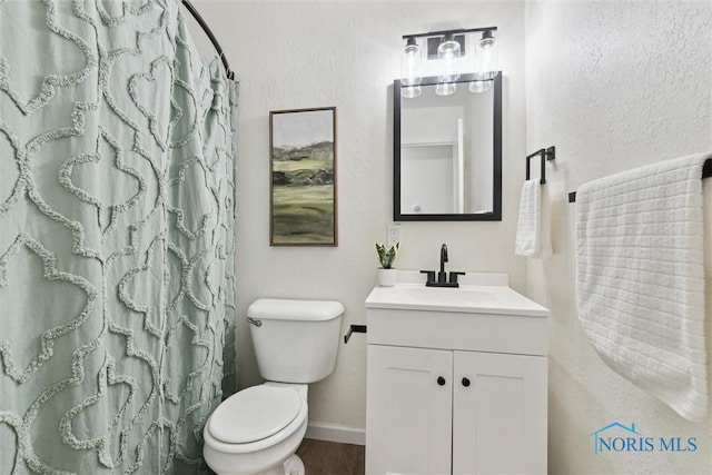 bathroom with vanity, curtained shower, and toilet