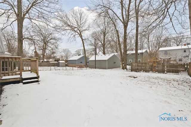 yard covered in snow featuring a wooden deck