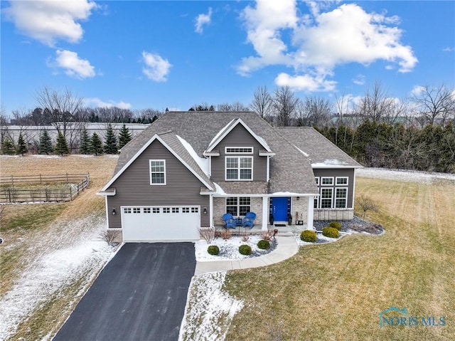 craftsman-style home with a garage, a front lawn, and covered porch