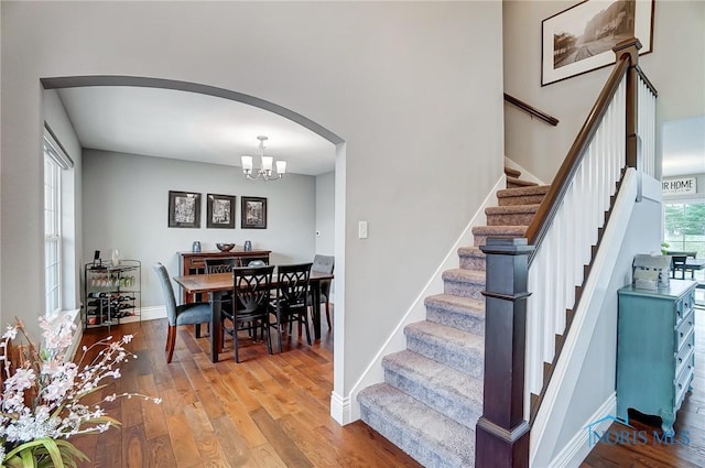 dining space with hardwood / wood-style floors and a notable chandelier