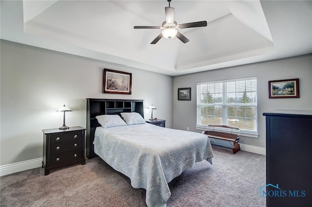 bedroom featuring a tray ceiling, carpet floors, and ceiling fan