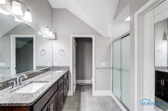 bathroom with lofted ceiling, vanity, toilet, and a shower with door