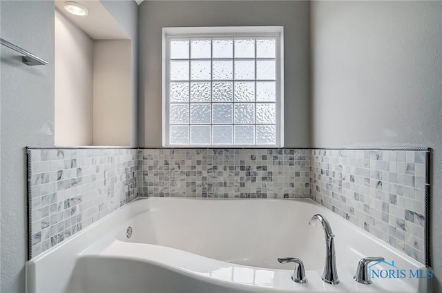 bathroom featuring a bathtub and a wealth of natural light