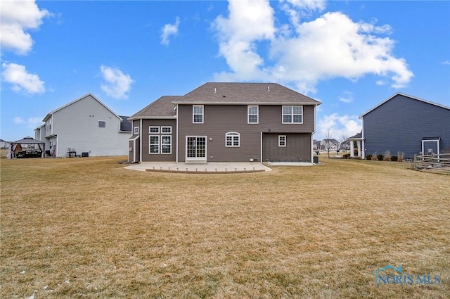 rear view of house with a lawn and a patio