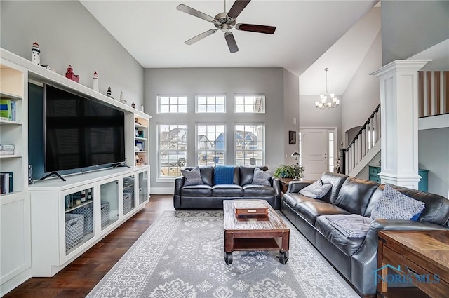 living room with ornate columns, a high ceiling, dark hardwood / wood-style floors, and ceiling fan with notable chandelier