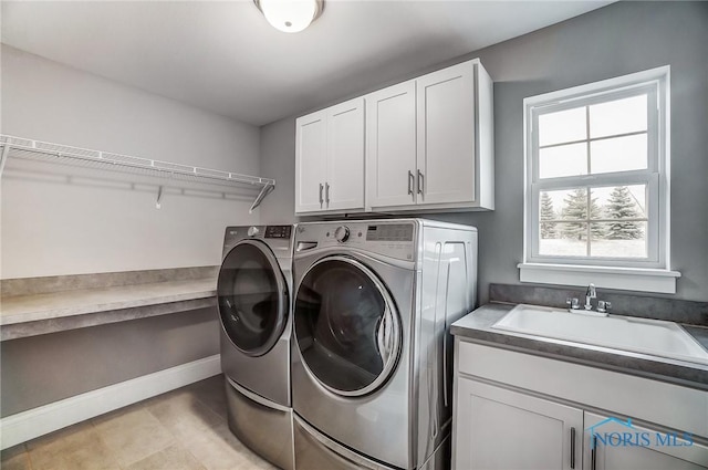 laundry room with cabinets, separate washer and dryer, and sink