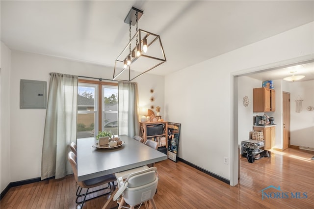 dining area with electric panel and light wood-type flooring