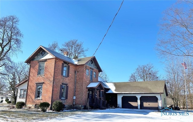 snow covered property featuring a garage