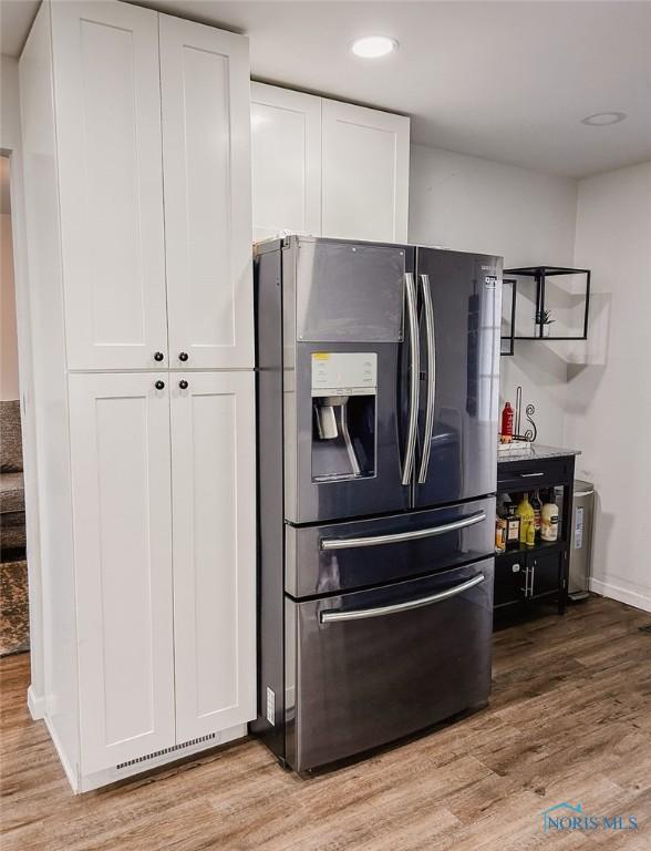 kitchen with white cabinetry, stainless steel fridge with ice dispenser, and light hardwood / wood-style flooring